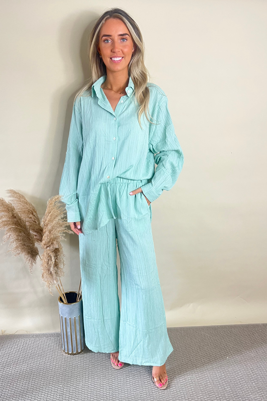 Elegant saliegroene getextureerde blouse en wijde pijpen broekset voor een chique uitstraling