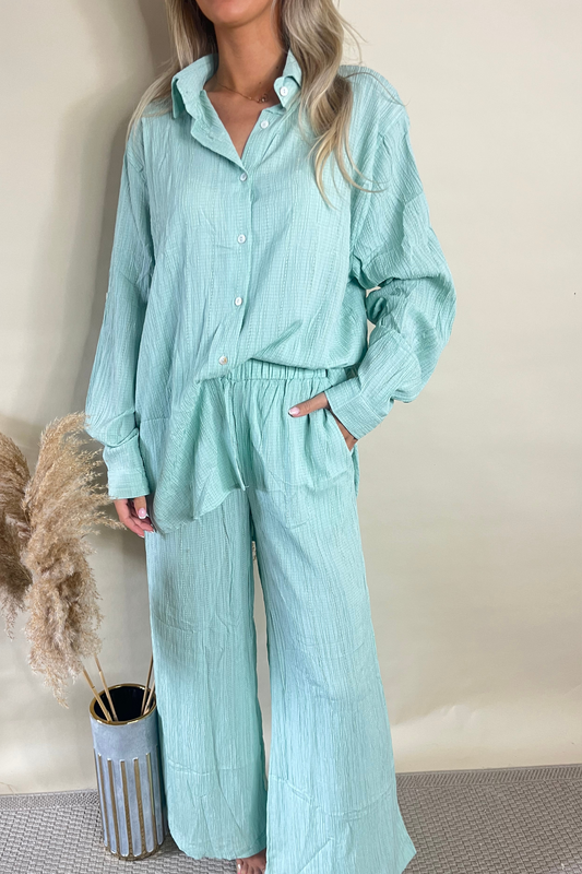 Elegant saliegroene getextureerde blouse en wijde pijpen broekset voor een chique uitstraling